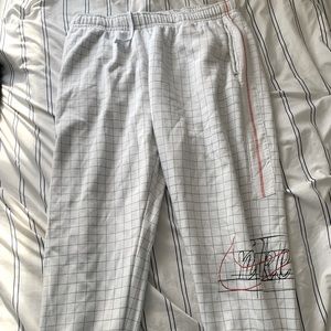 White Nike gridded joggers, with red and black logo